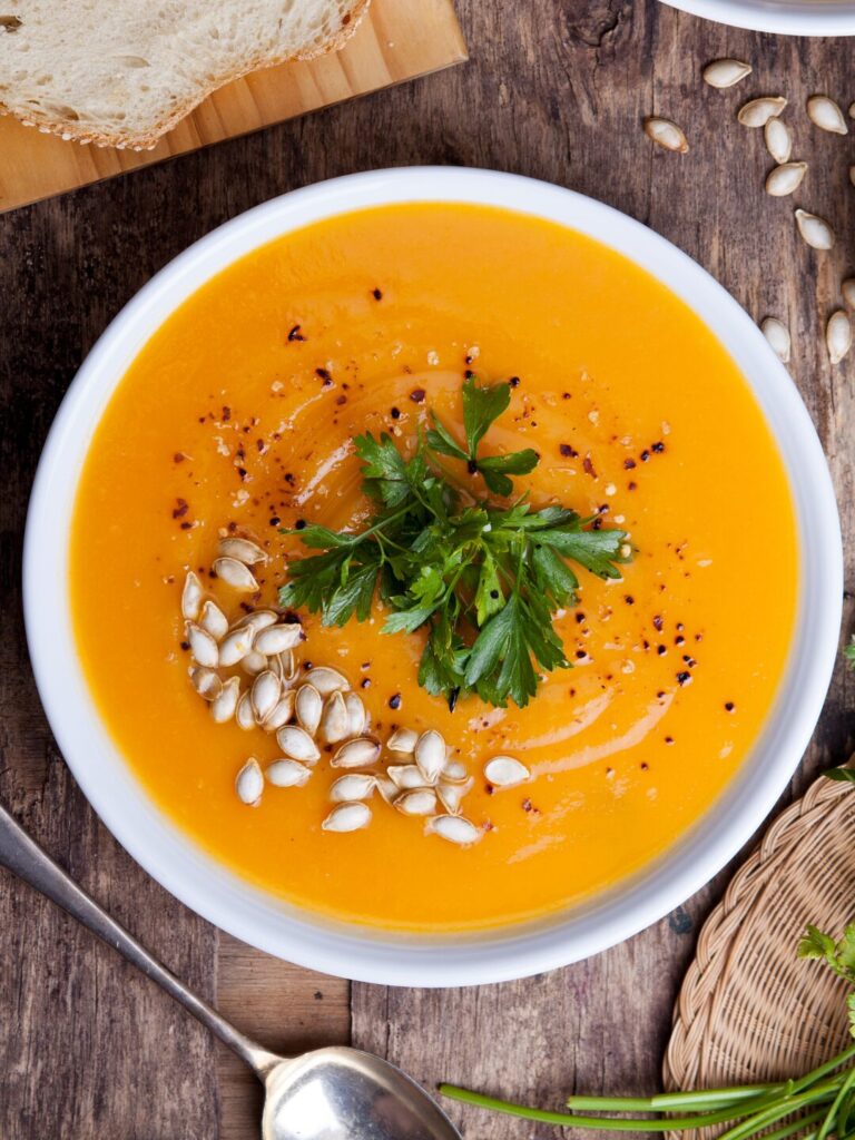 かぼちゃのクリーミースープにパセリとパンプキンシードを添えた一皿